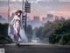 A woman in a white dress and hat walking down a street.