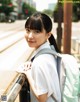 A young woman with a backpack leaning against a railing.