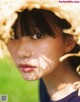 A young woman wearing a straw hat in the grass.