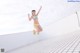 A woman in a bikini jumping in the air.