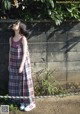 A woman standing in front of a brick wall.