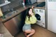 A woman sitting on the floor in front of a washing machine.