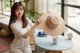 A woman sitting at a table with a hat on.