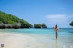 A woman standing in the shallow water of a beach.