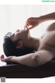 A naked woman laying on top of a wooden table.